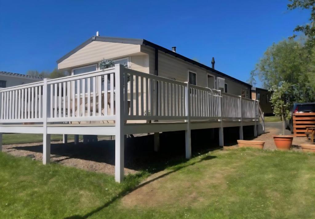 a house with a white deck in the yard at Seashells - Exclusive Private Area to Side in Coldingham