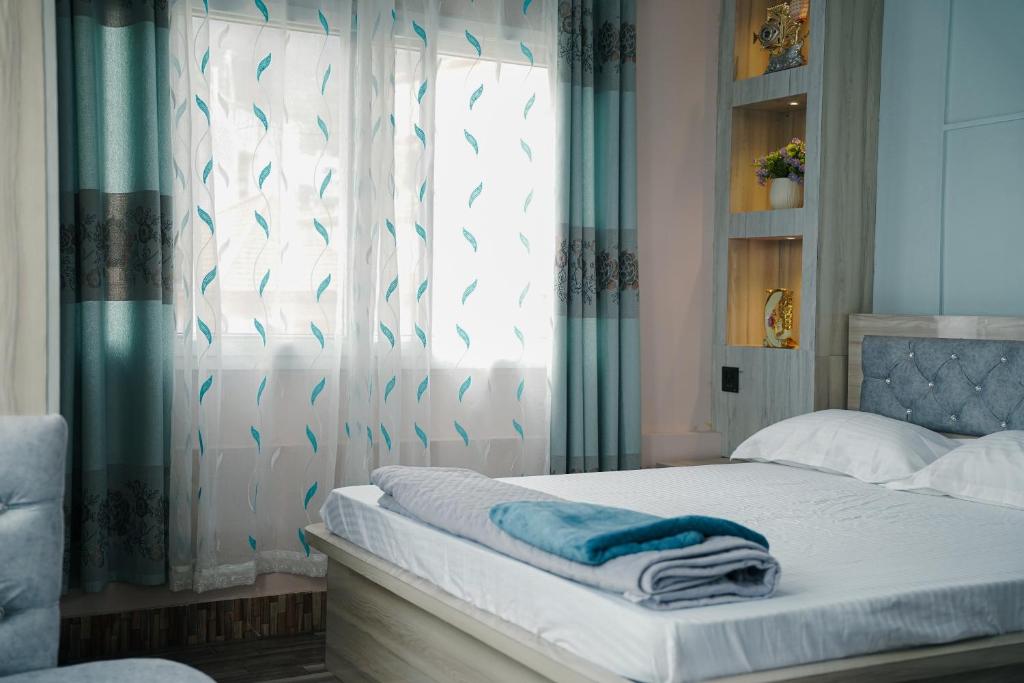 a bedroom with a bed with a window at Kathmandu Mountain view Studio in Bālāju