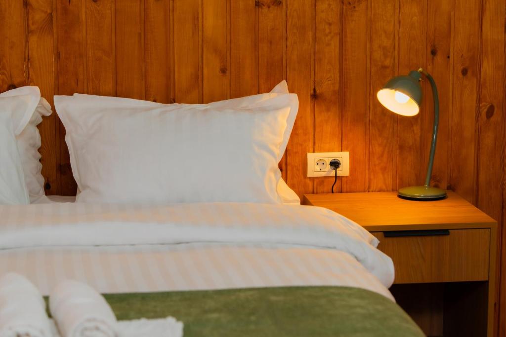 a bedroom with a bed and a lamp on a table at Pescariei Nr5 in Sarichioi