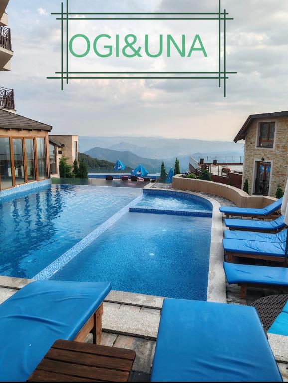 a pool at a hotel with blue tables and chairs at Ogi & Una Premijer 42 in Kopaonik