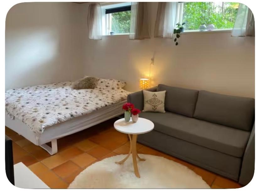 a living room with a couch and a table at Skøn perle midt i naturen in Munke Bjergby