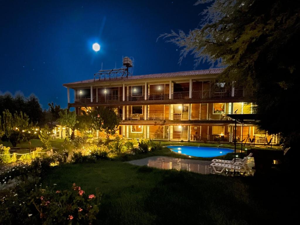 a house with a swimming pool at night at Runaway Hotel in Carhuaz