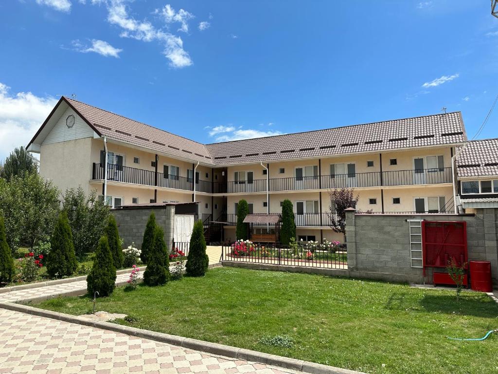 a large building with a lawn in front of it at Jany Tilek in Bosteri