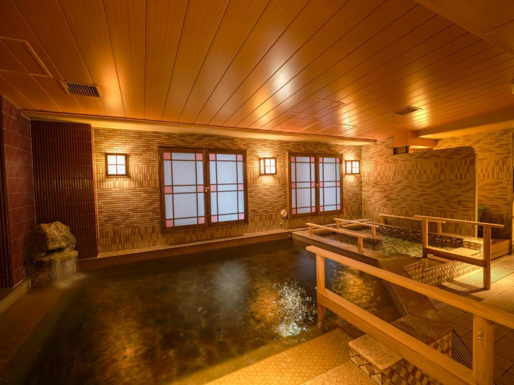 an indoor swimming pool in a building with a wooden ceiling at Dormy Inn Hiroshima in Hiroshima