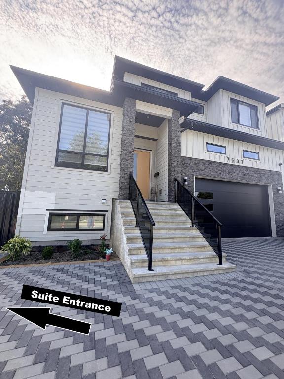a white house with a staircase in front of it at Guest Suite in Mission in Mission