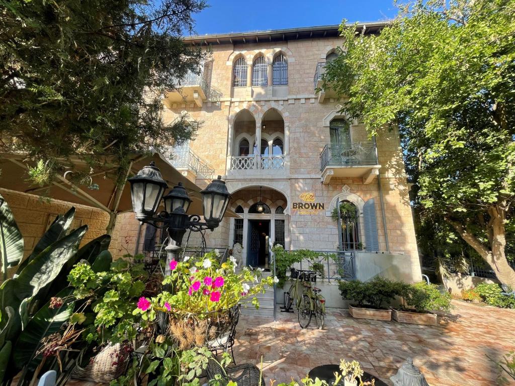 a building with flowers in front of it at Villa Brown Moshava - a member of Brown Hotels in Jerusalem