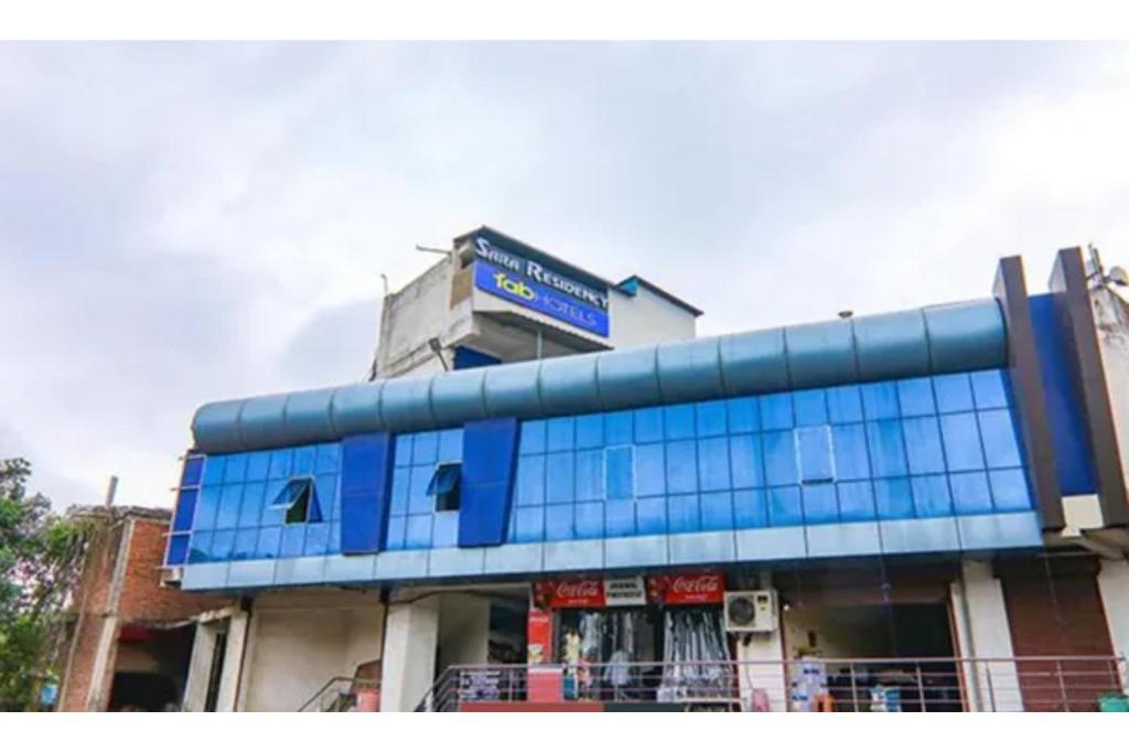 a blue building with a sign on top of it at FabHotel Sara Residency in Prayagraj