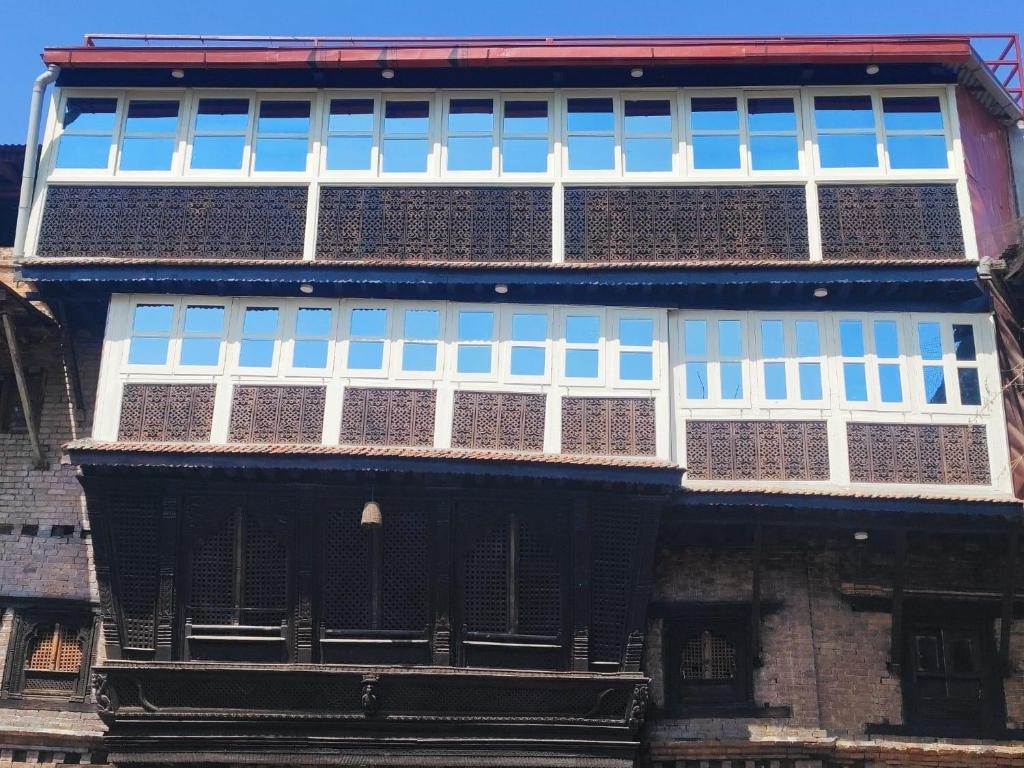 a building with blue and white windows on it at Sanjhyā Durbar Homestay in Bhaktapur