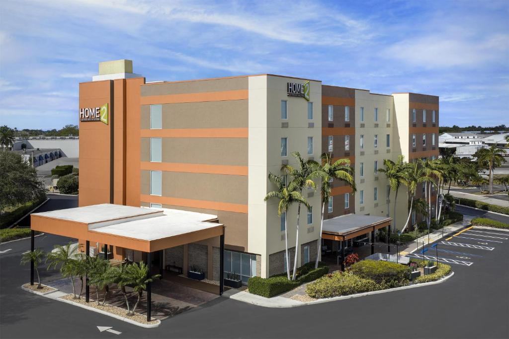 a hotel building with palm trees in a parking lot at Home2 Suites by Hilton Florida City in Florida City