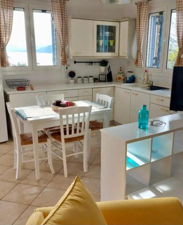 a kitchen with a table and a white table and chairs at Myrto Signature Suite - Aegina in Aegenitissa