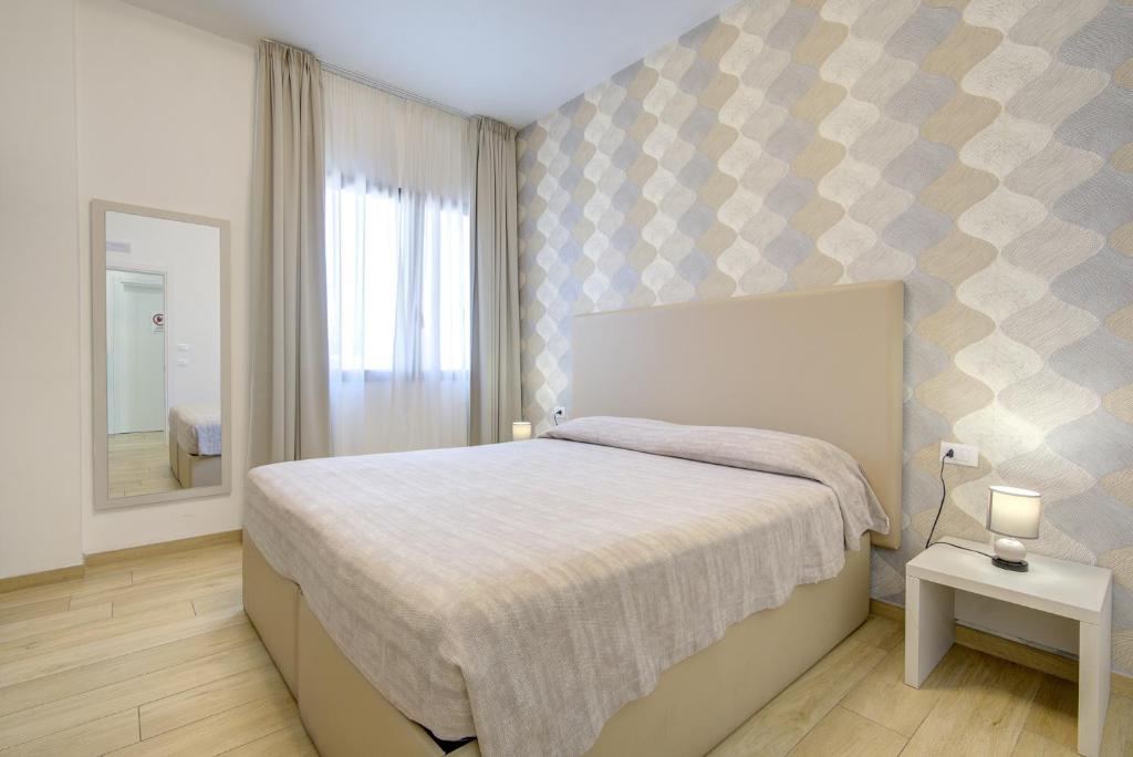 a bedroom with a bed and a mirror at Guest House al porto in Civitavecchia