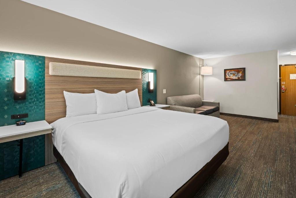 a hotel room with a large bed and a chair at Econo Lodge Inn & Suites Santa Fe South in Santa Fe