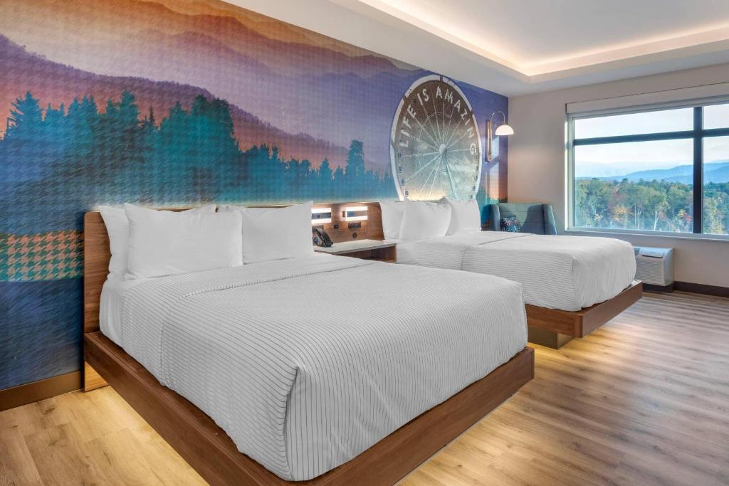 a hotel room with two beds and a mural at Cambria Hotel Pigeon Forge in Pigeon Forge