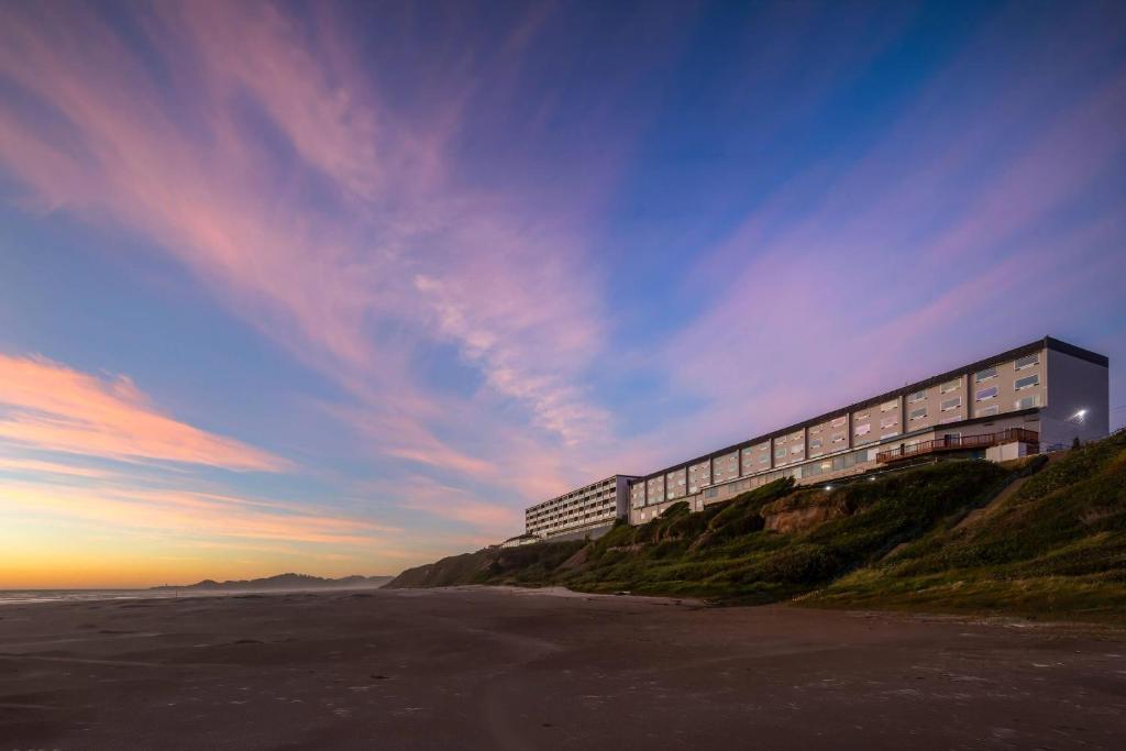 a building on top of a hill next to the beach at Newport Oceanfront Inn in Newport