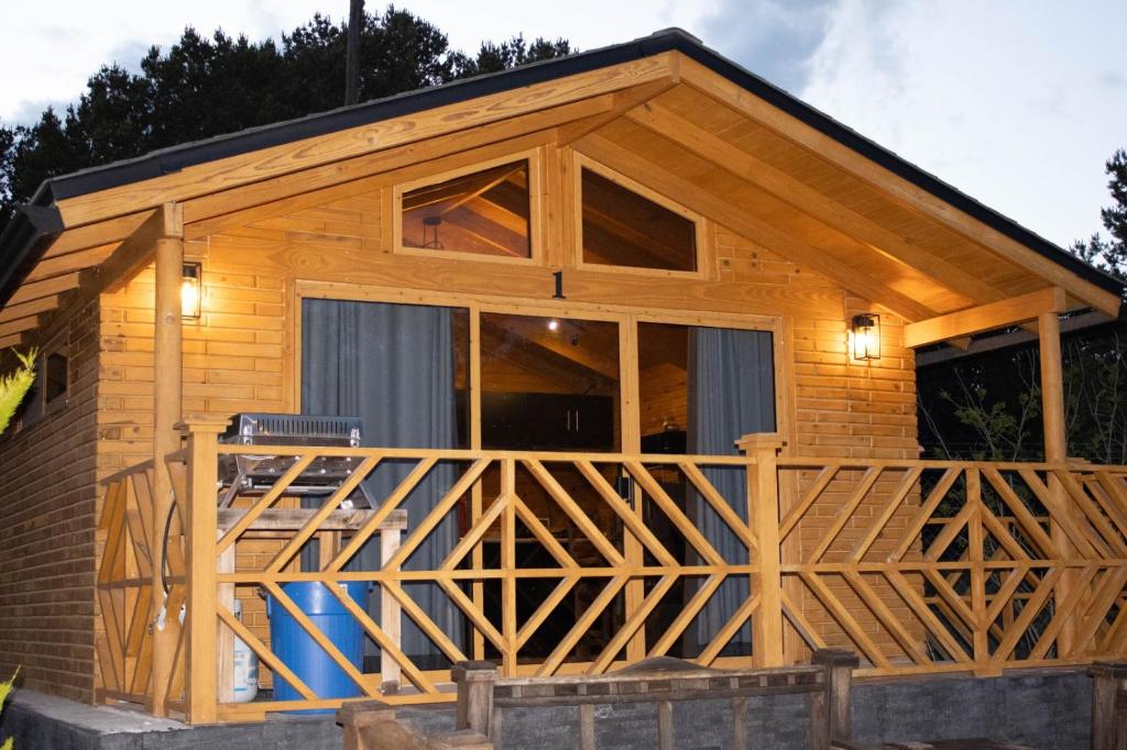 a log cabin with a large deck at Pinitos Old Ranch & Cabañas in El Cristal