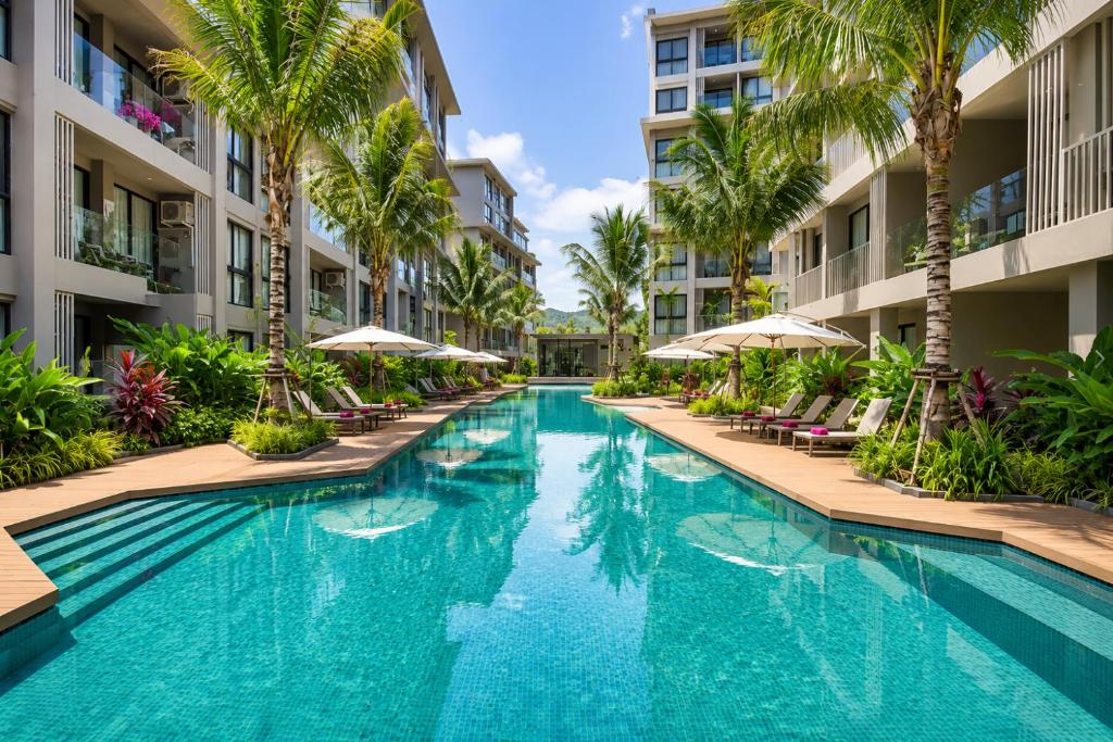 an infinity pool at a hotel with palm trees and umbrellas at Pool View 1 BR Apt for 3 - Diamond Condo 5209 in Bang Tao Beach