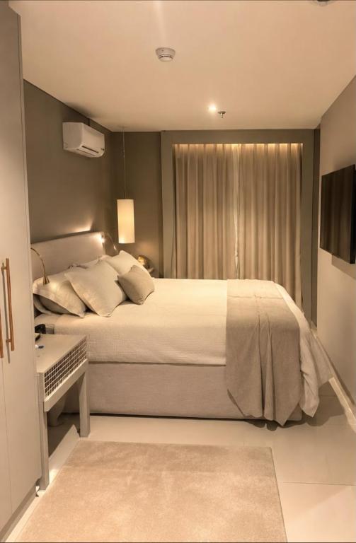 a bedroom with a large bed and a window at Comfortable Serviced Apartment by the Lake in Brasília