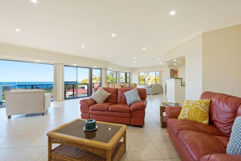 a living room with two couches and a table at Kyeema in Tathra