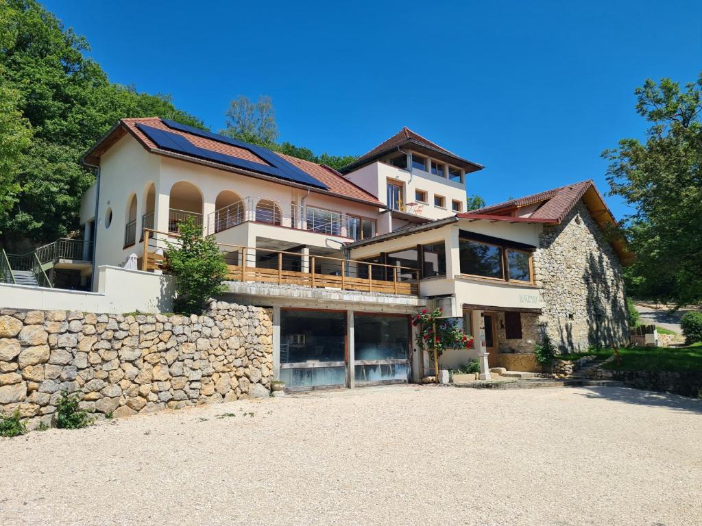 a large house on top of a stone wall at Le Vernay en Savoie - Petit Hôtel Nature in Saint-Maurice-de-Rotherens