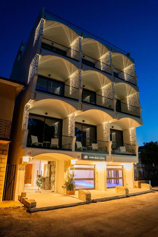 a large apartment building with a lit facade at night at Aeon Blue in Selianitika