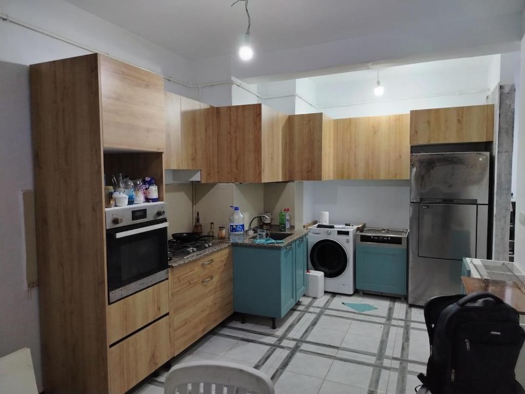 a kitchen with wooden cabinets and blue appliances at Apartment rental for vacations in Boumerdes