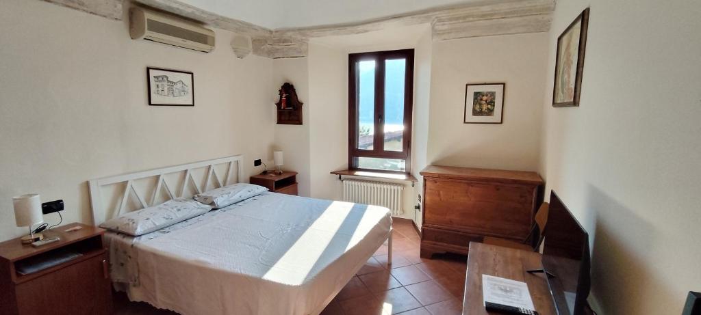a bedroom with a bed and a window at Dimora Fenni - Appartamento elegante nel cuore di Monte Isola con Wi-Fi e aria condizionata in Monte Isola