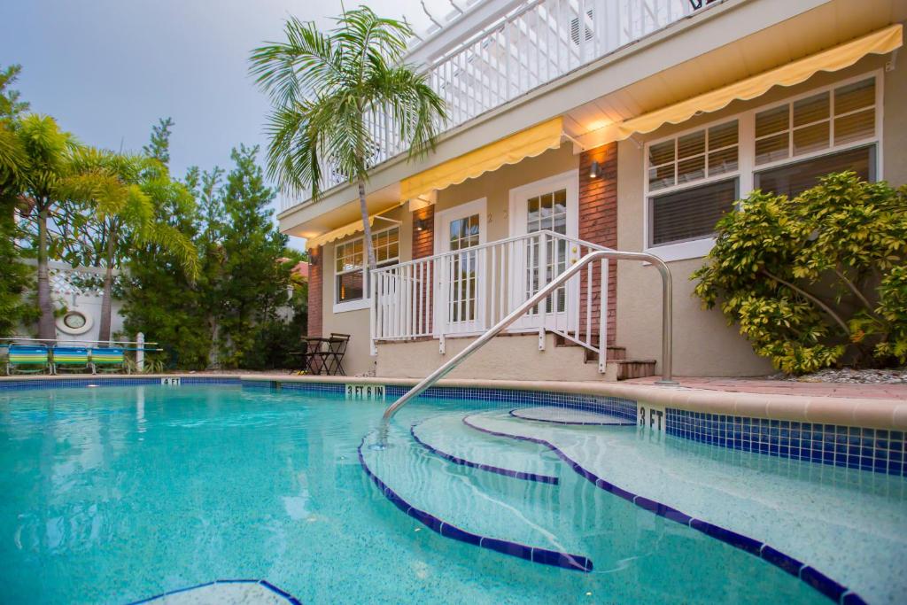 a swimming pool in front of a house at Coconut Inn Pass-a-Grille Beach in St. Pete Beach