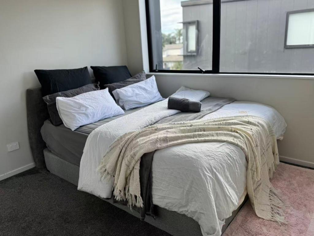 a bed with a blanket on it in a bedroom at Duo Duo in Auckland