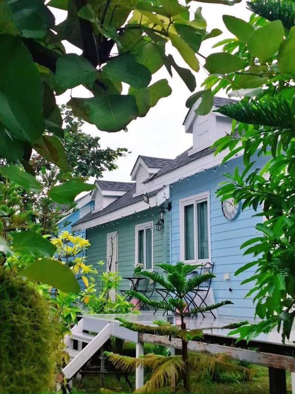 a blue house with a tree in front of it at Peang Tara Cafe & Resort in Nong Khai