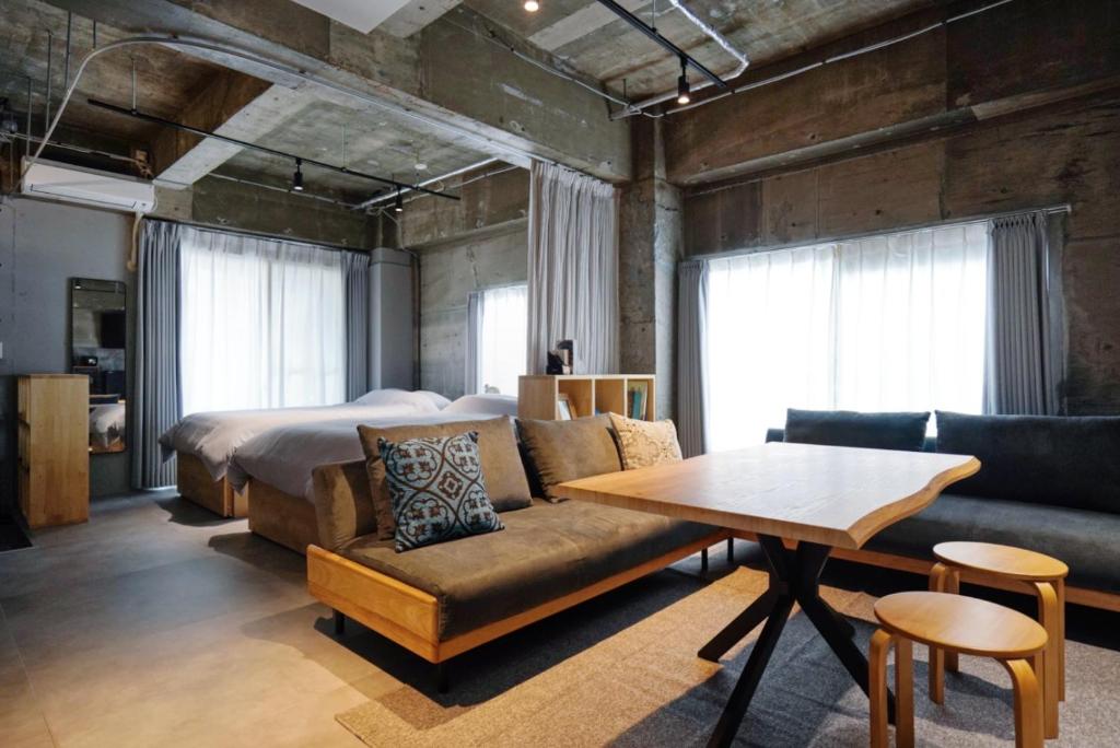 a bedroom with a bed and a couch and a table at Liminal in Atami