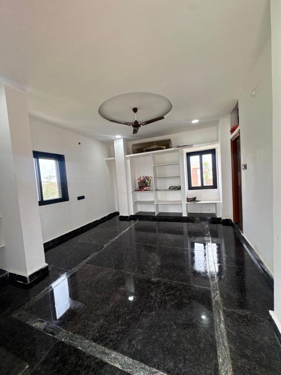 an empty living room with a ceiling at Nishhh stay in Surūrnagar