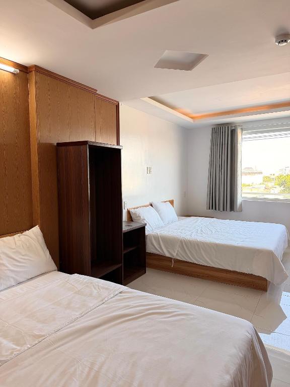 a hotel room with two beds and a window at Khách sạn Lumea in Cam Ranh
