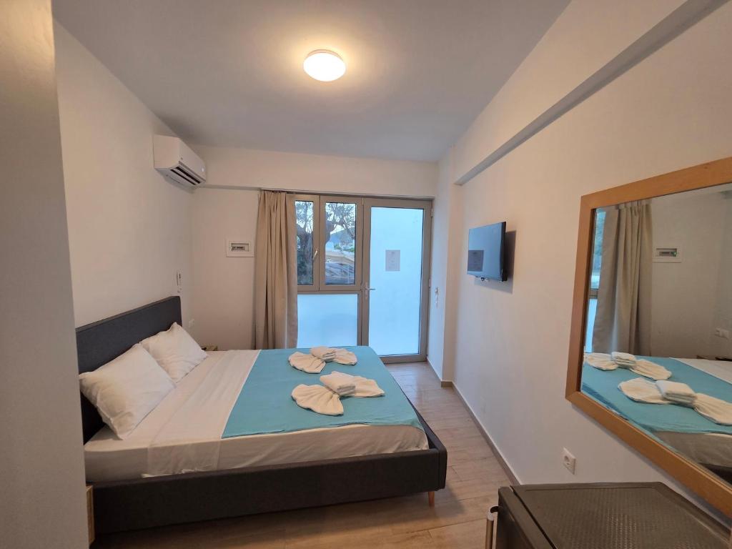 a bedroom with a bed and a mirror at VasilikiApartments in Vasiliki