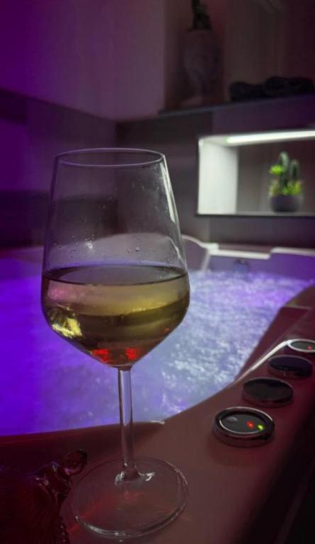 a glass of wine sitting on a table next to a pool at Holiday Luxury Room in Giardini Naxos