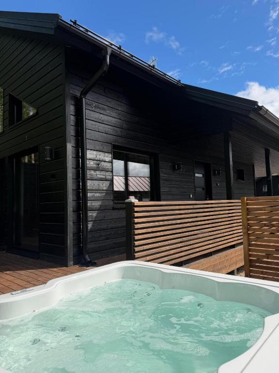 a hot tub on a deck next to a house at Himos Siesta Porealtaalla ja loppusiivouksella in Jämsä