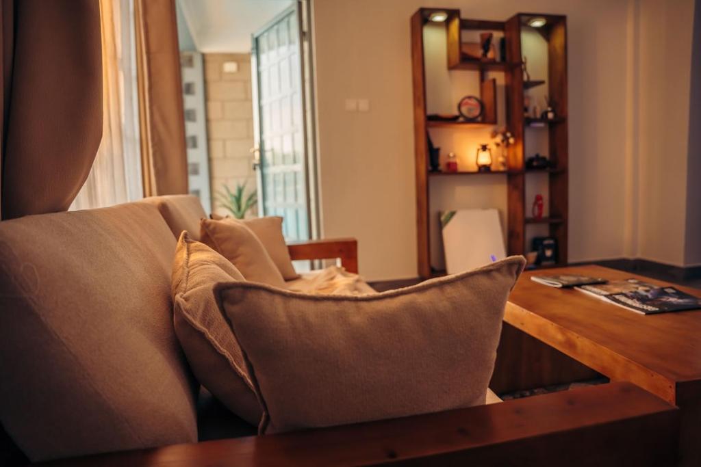 a living room with a couch and a table with pillows at Lights & Kulture Homes in Arusha