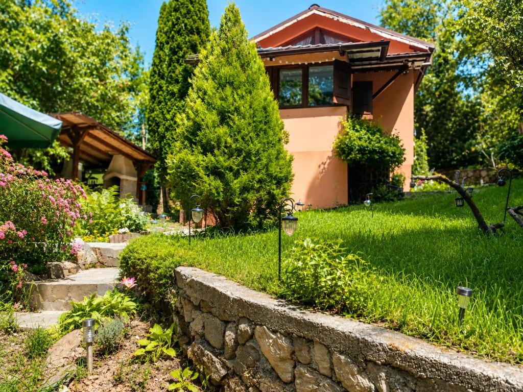 Ein Haus mit einer Steinmauer vor dem Hof in der Unterkunft La Cascade - Casa de vacanta in Fîntînele