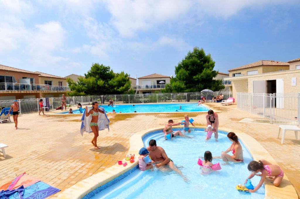 a group of people playing in a swimming pool at Résidence Goélia Les Jardins De Phoebus in Gruissan