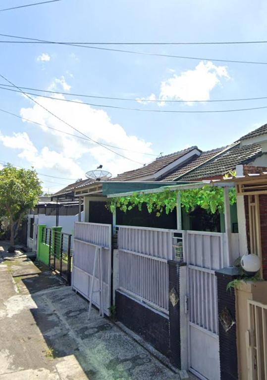 a row of houses with a white fence at Gs Homestay in Banyuwangi