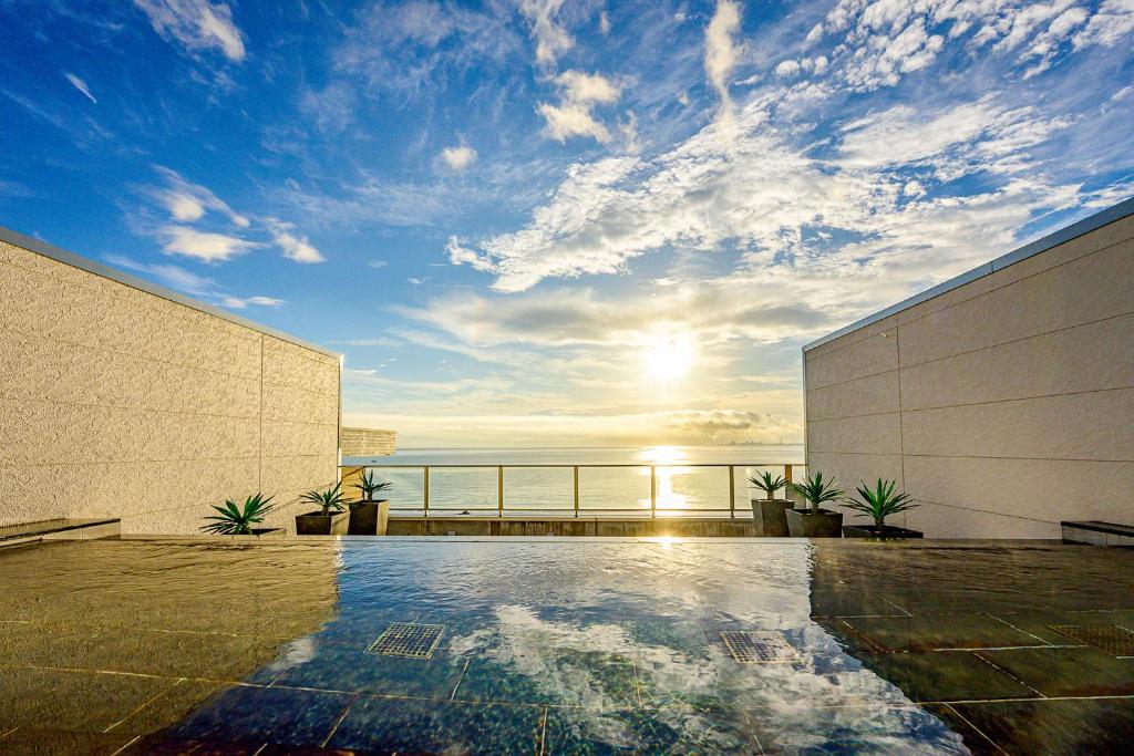 a swimming pool on a building with a view of the ocean at Ooedo Onsen Monogatari Beppu Seifu in Beppu