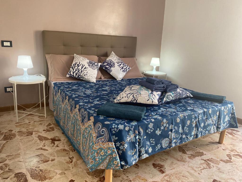 a bedroom with a bed with blue sheets and pillows at Bonita Cora in Pachino