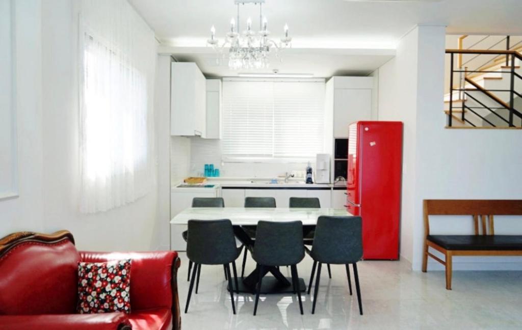 a kitchen with a table and chairs and a red refrigerator at 판포홈치풀빌라 in Wŏllyŏng