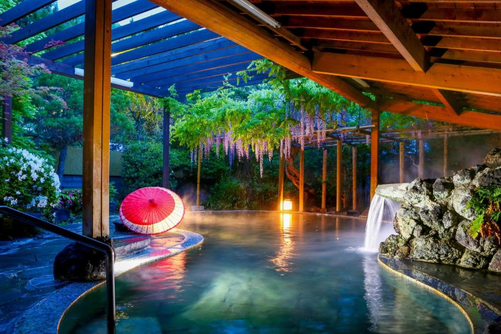 a swimming pool with a waterfall in a resort at Ooedo Onsen Monogatari Shinshu Kakeyu in Ueda