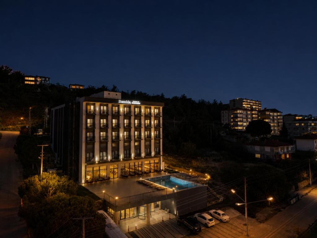a building with a pool in front of it at night at Remida Managed By Dedeman in İntepe
