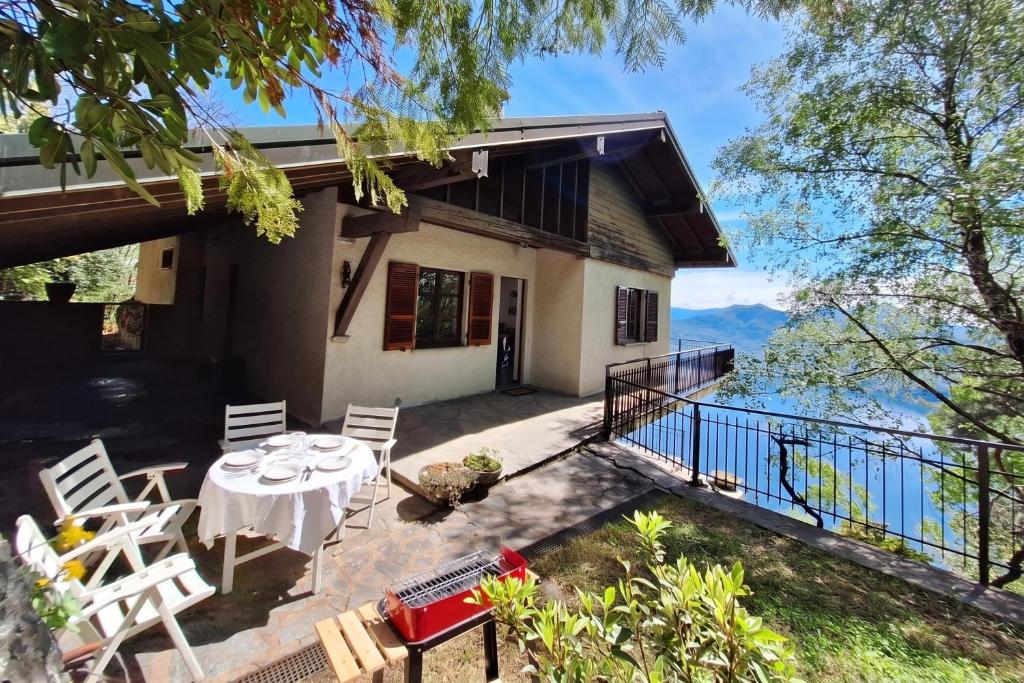 a house with a balcony with a table and chairs at Lago Azzurro Villa: Infinity Lake View - Happy Rentals in Premeno