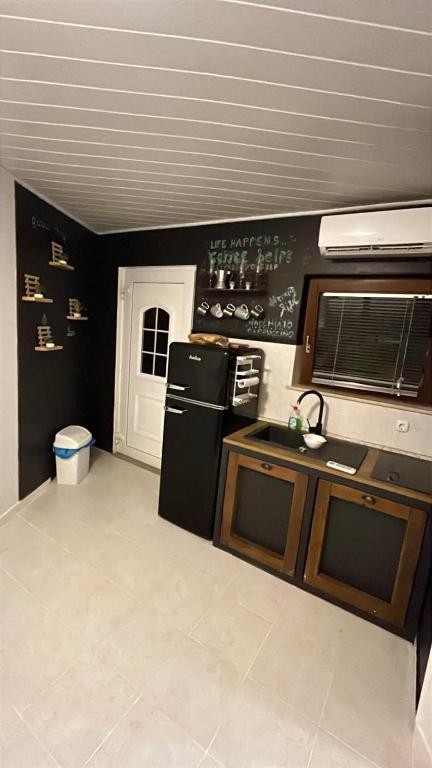 a kitchen with a black refrigerator and a sink at Parenzana Apartment in Portorož