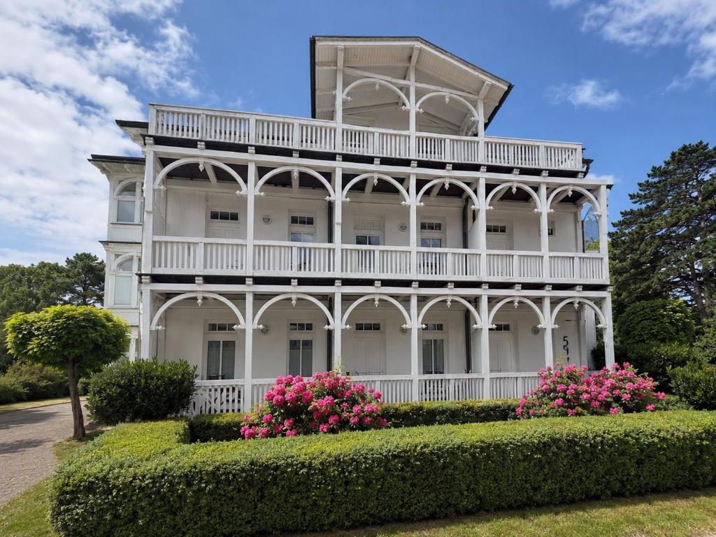 a white house with pink flowers in front of it at Villa Jugendglück in Binz