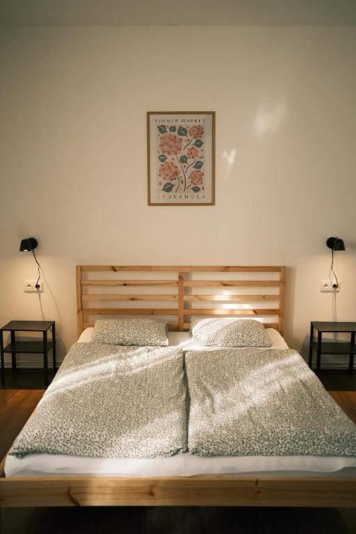 two beds in a bedroom with two lamps and a picture on the wall at Chata Horalka in Jáchymov