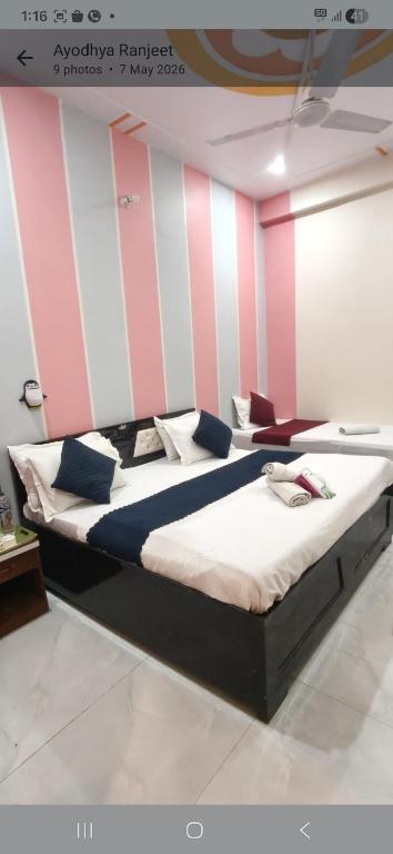 two beds in a room with pink and white stripes at KHS ROOMs near ghat and temples in Varanasi