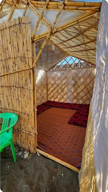 an inside view of a tent with a green bench at ESPACE AZAiMi in Tarîfa